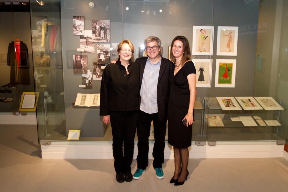 Three people posing in front of a photo gallery.