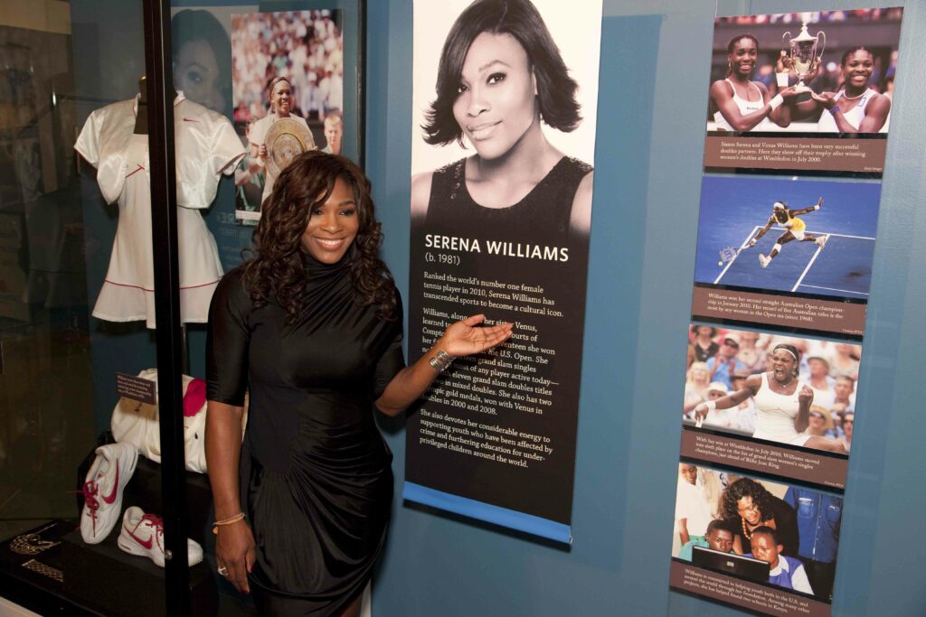 Serena Williams posing in front of her exhibit.