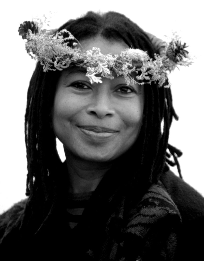 Headshot of a pleasantly smiling Alice Walker wearing a flower crown.