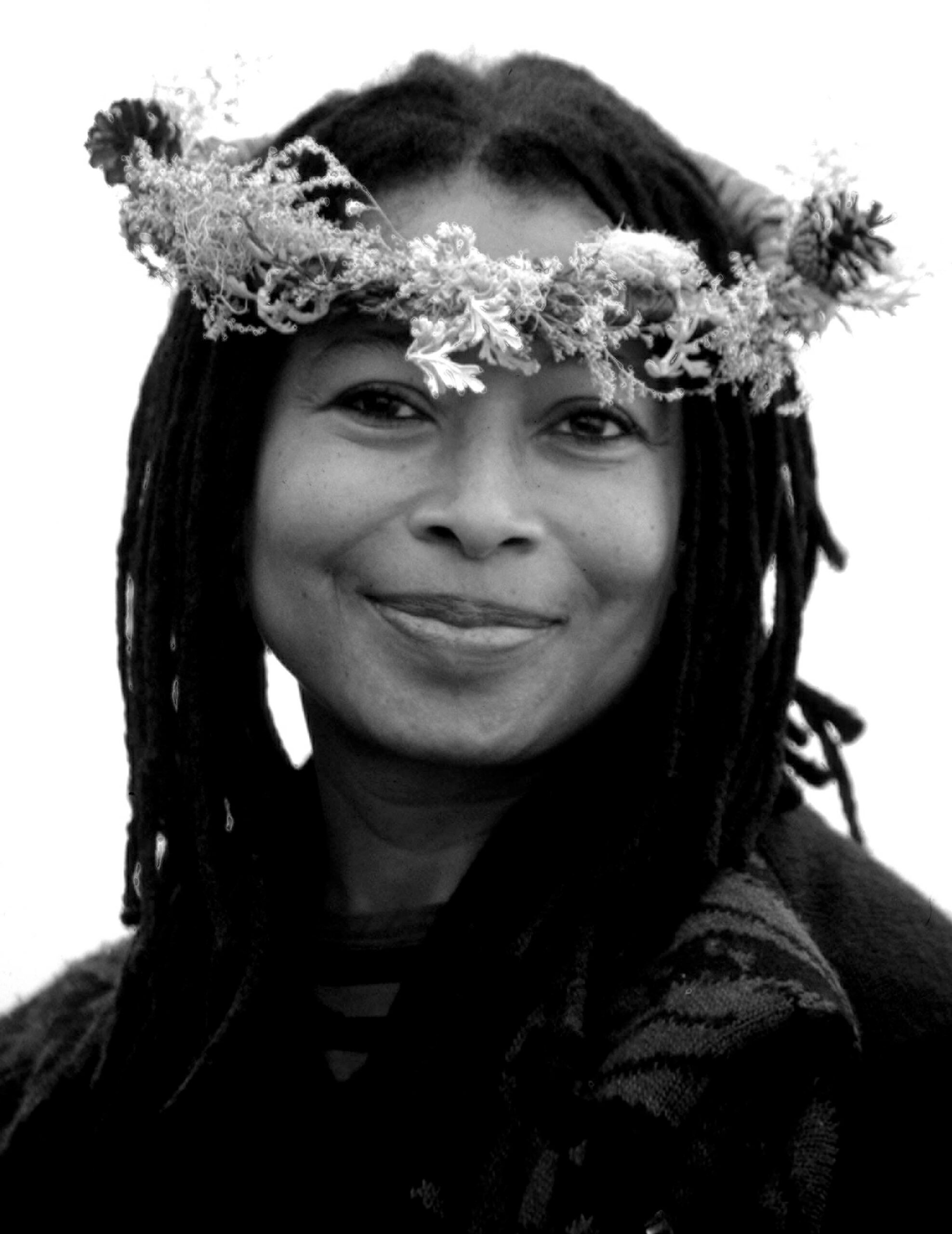 Headshot of a pleasantly smiling Alice Walker wearing a flower crown.