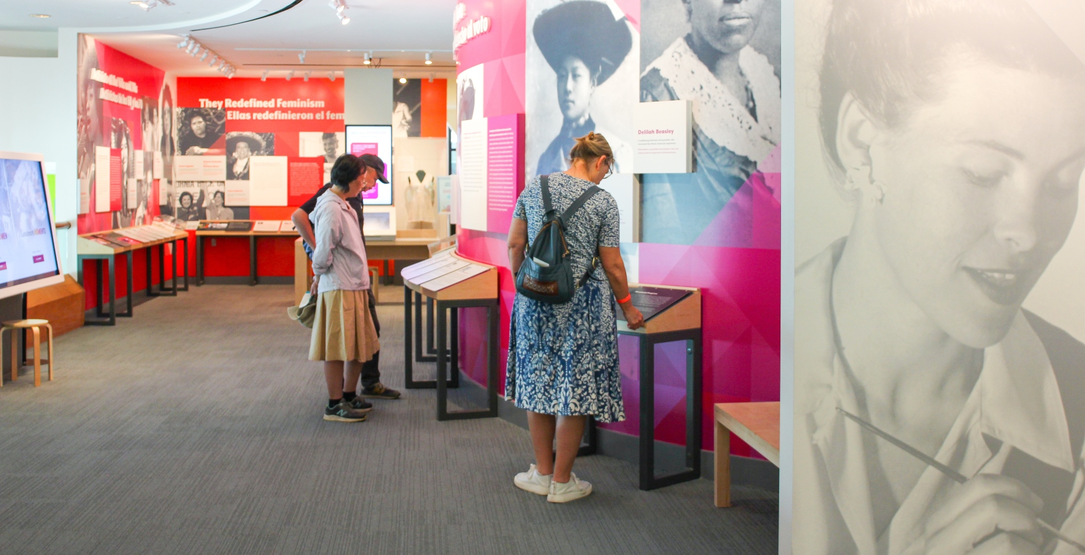 Museum visitors reading informational panels in the Women Inspire gallery.