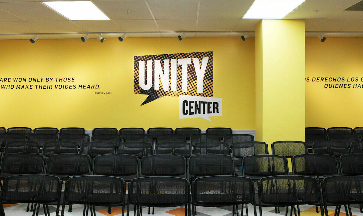 Empty chairs arranged in rows with the Unity Center logo in the background.