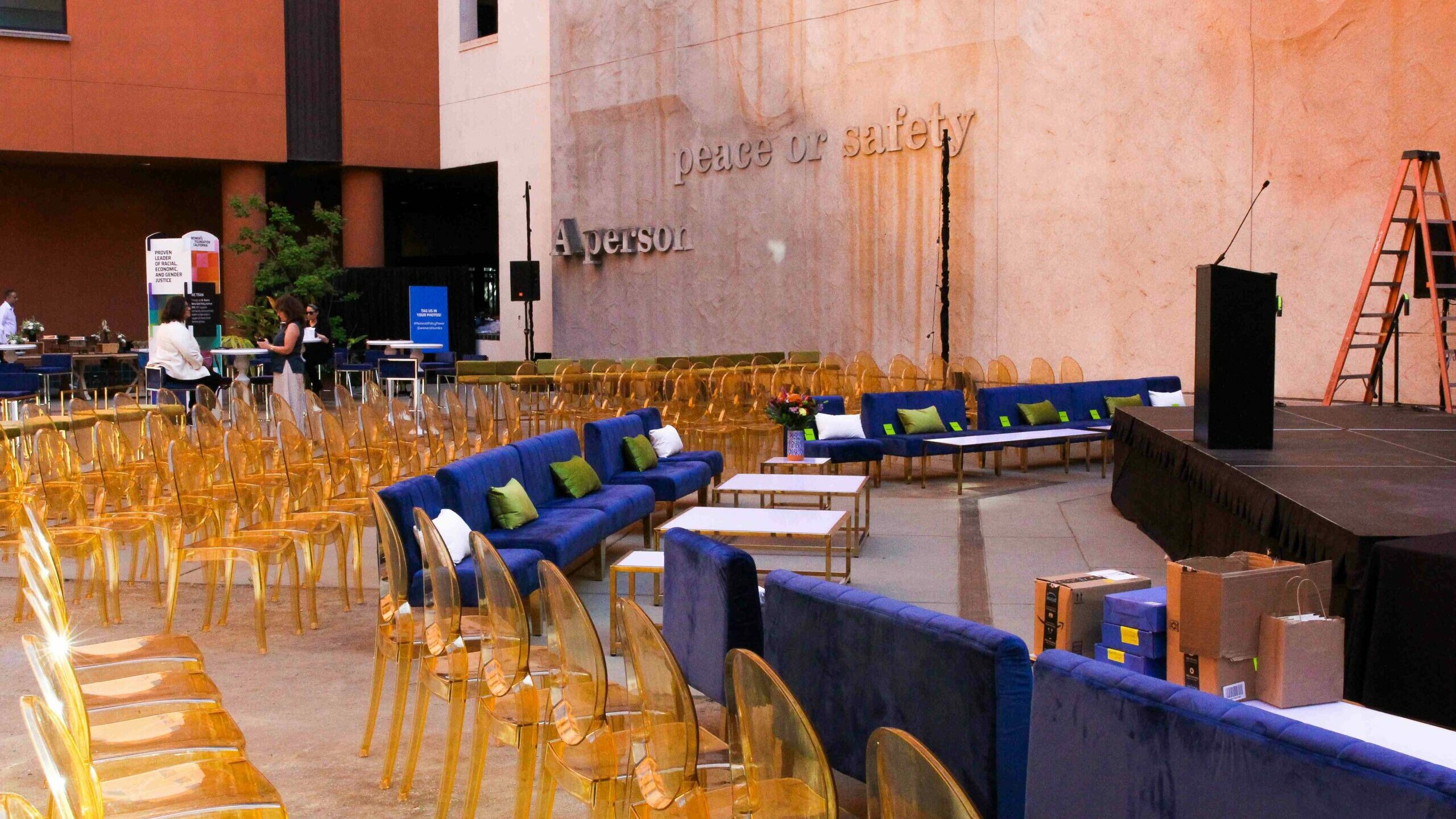 Chairs arranged in rows in front a stage in the museum courtyard.