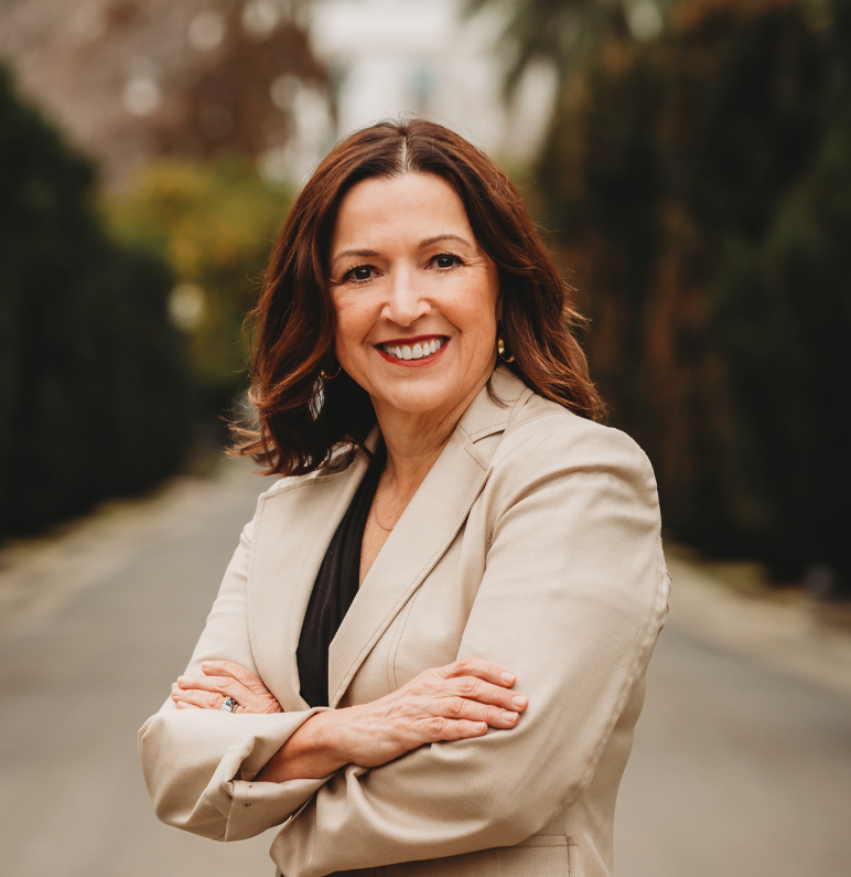 Kristen Soares poses on State Capitol grounds with her arms gently crossed.