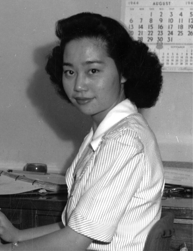 Mitsuye Endo looking at the camera while working at a desk.