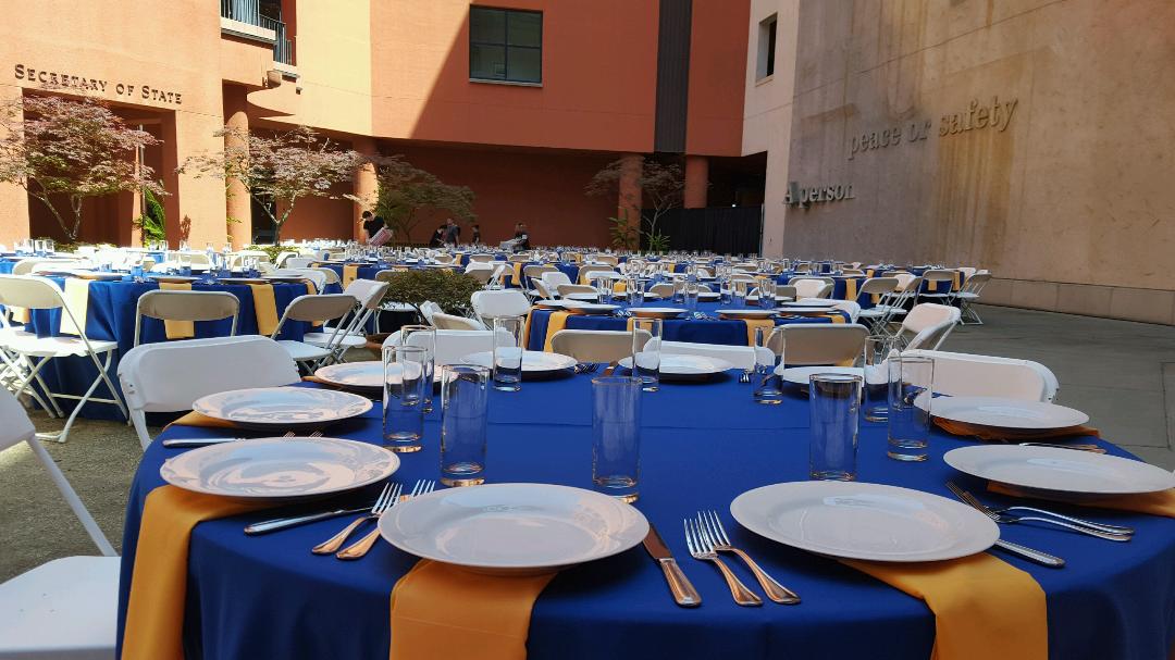 Place settings on round tables in the museum courtyard.