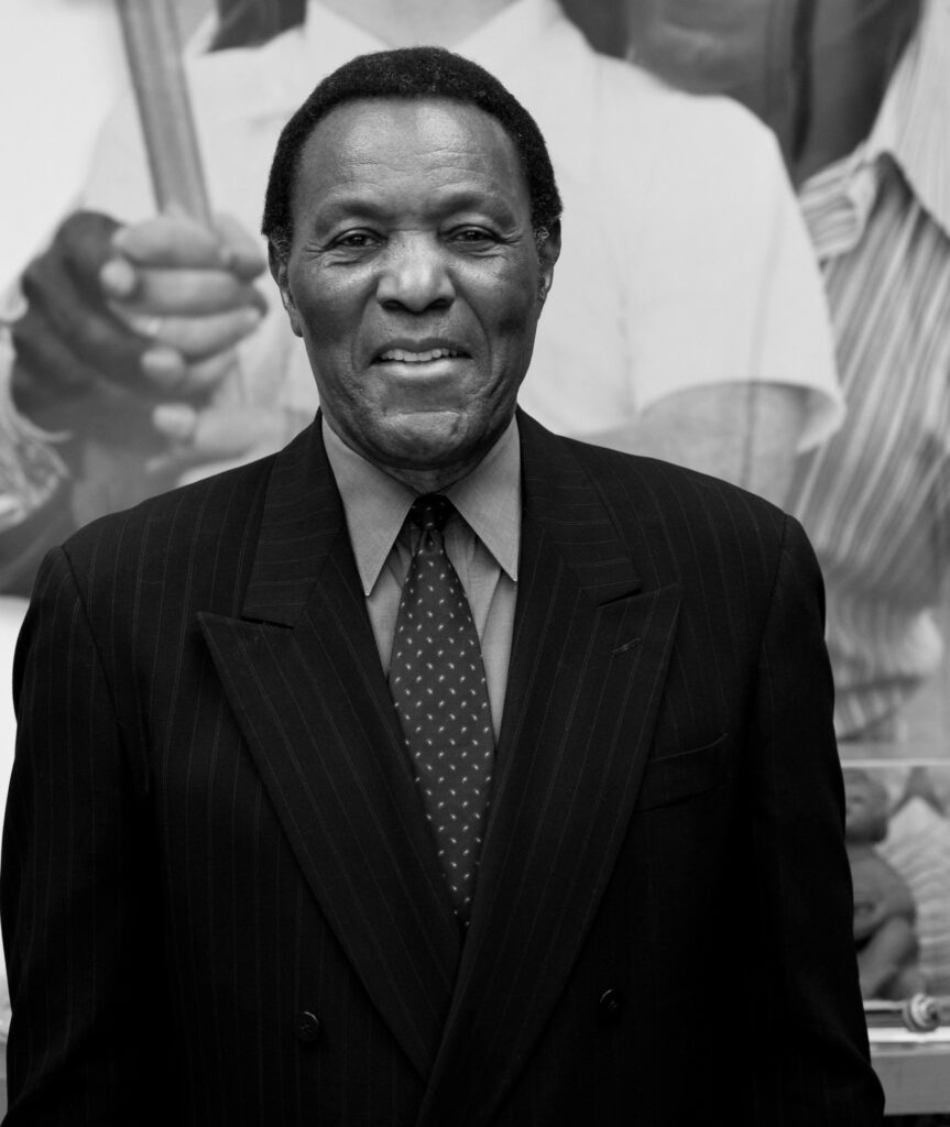 Rafer Johnson sports a suit and tie and a warm smile.