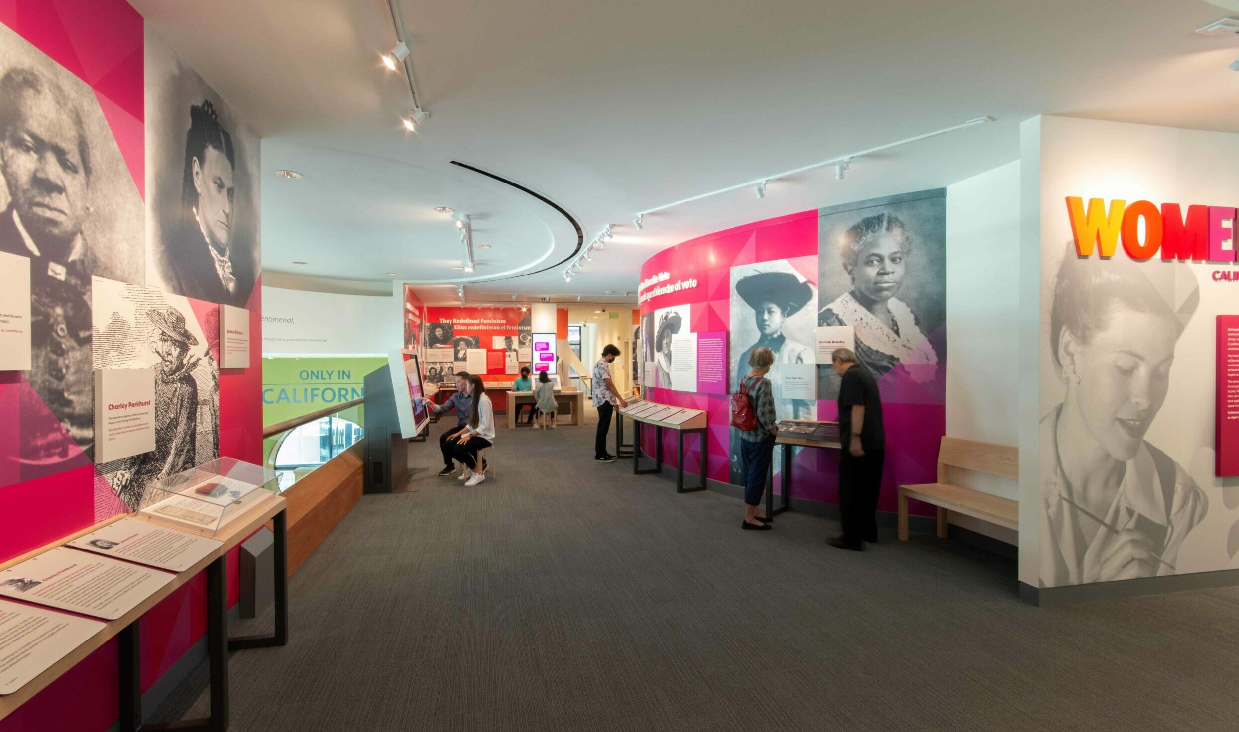 Museum visitors using interactive elements in the Women Inspire gallery.