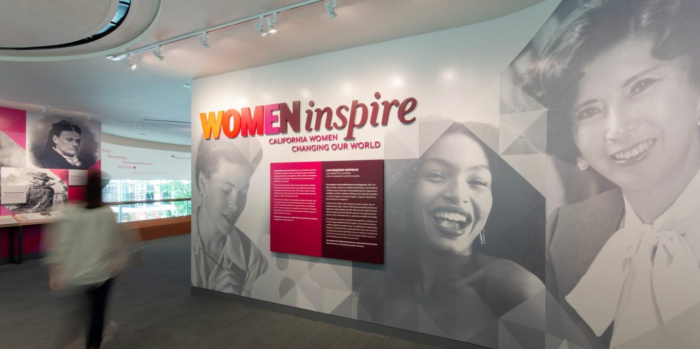 A museum visitor walks through the Women Inspire exhibit.