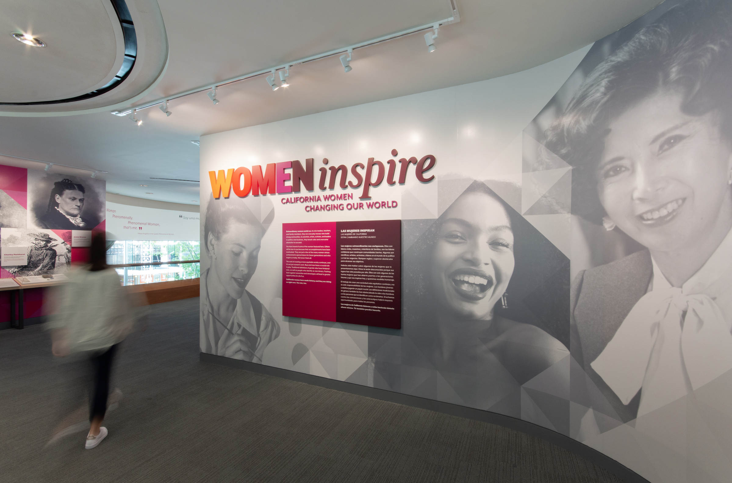 Woman walking by Woman Inspire exhibit at the California Museum