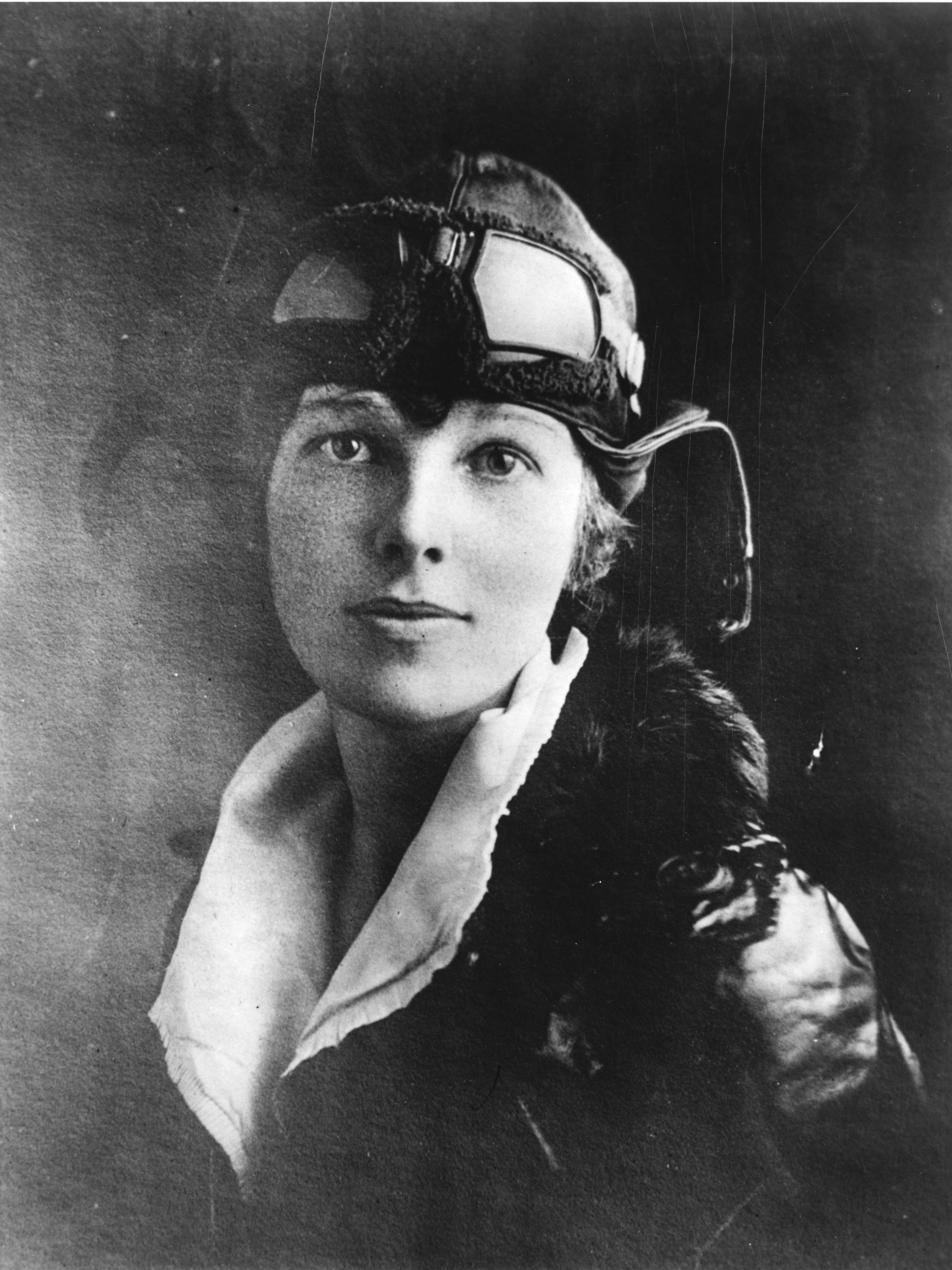 Headshot of Amelia Earhart wearing an aviator hat and jacket.