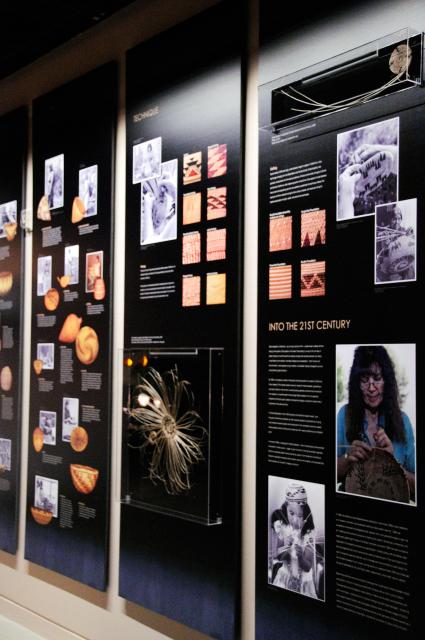 A gallery wall with baskets, photos, and other artifacts.