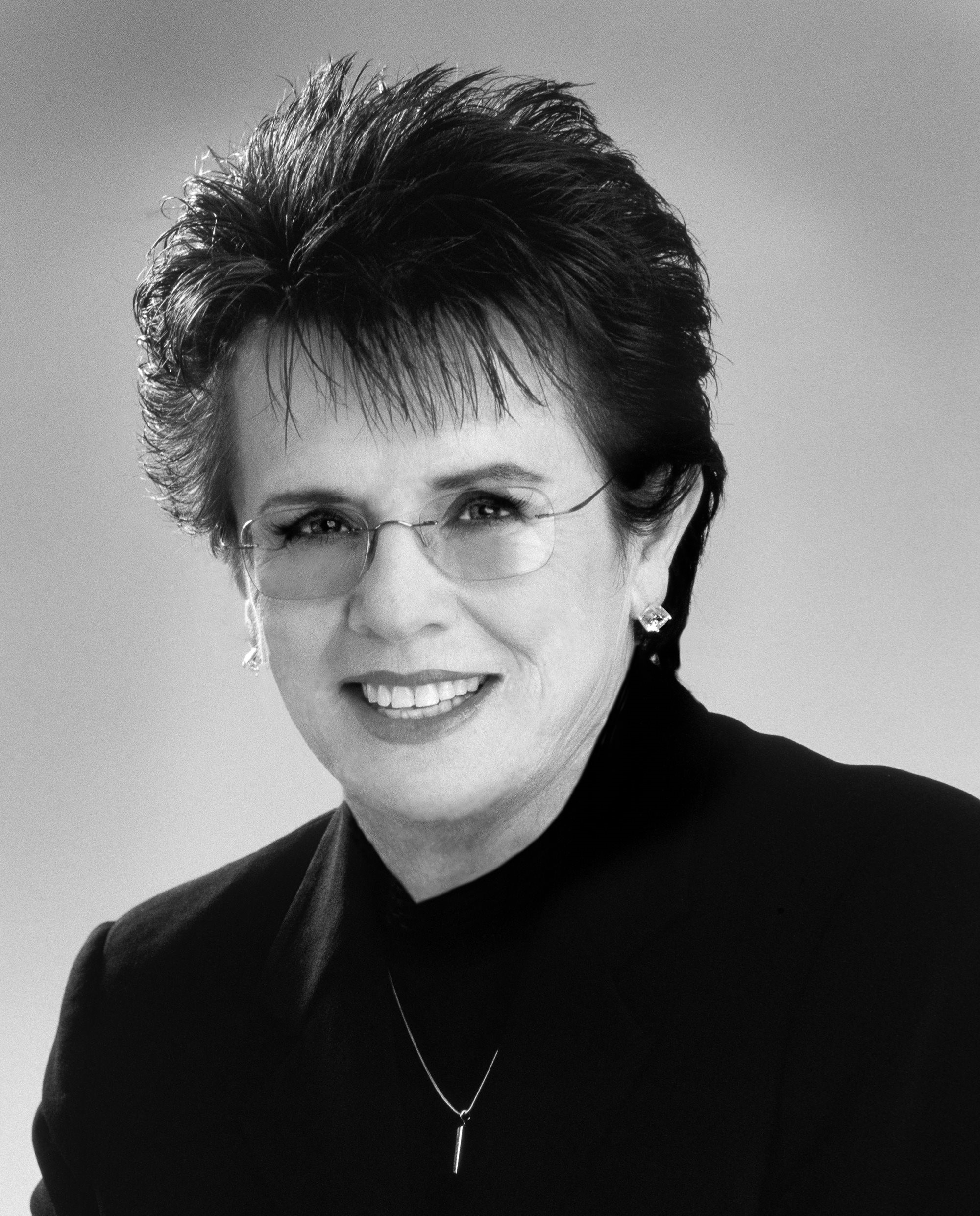 Headshot of a smiling and dressed-up Billie Jean King.