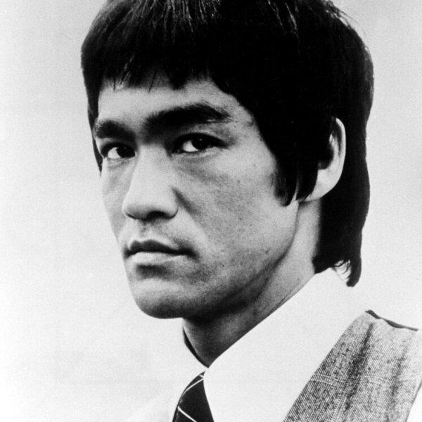 A young Bruce Lee gazes sternly while wearing a tie.