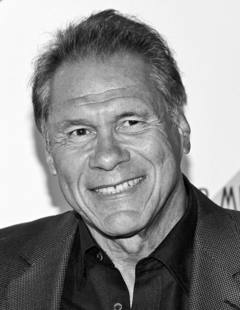 Headshot of Jim Plunkett wearing a suit jacket.