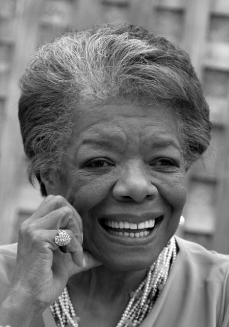 Maya Angelou with a glowing smile and a soft hand at her cheek.