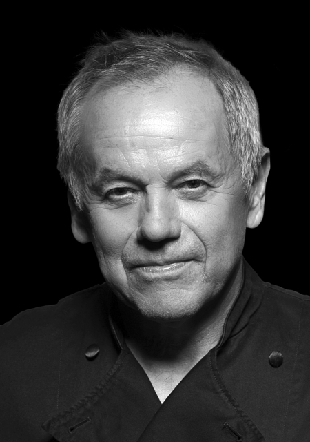 Headshot of a serious Wolfgang Puck wearing a chef coat.