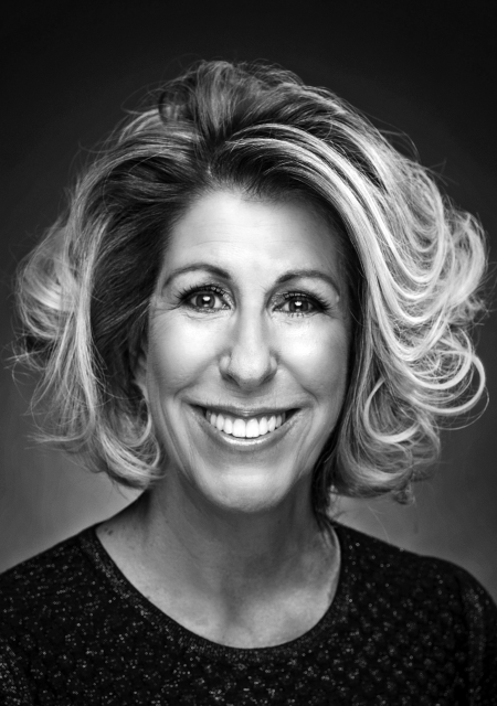 Headshot of a smiling Nancy McFadden with voluminous hair.