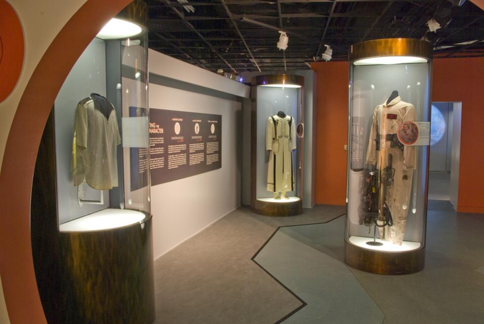 Costumes in display cases in a gallery.