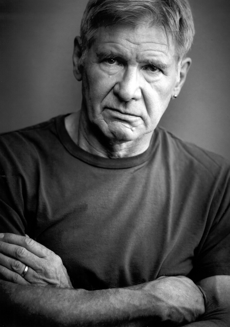 Harrison Ford crosses his arms with a stern expression.
