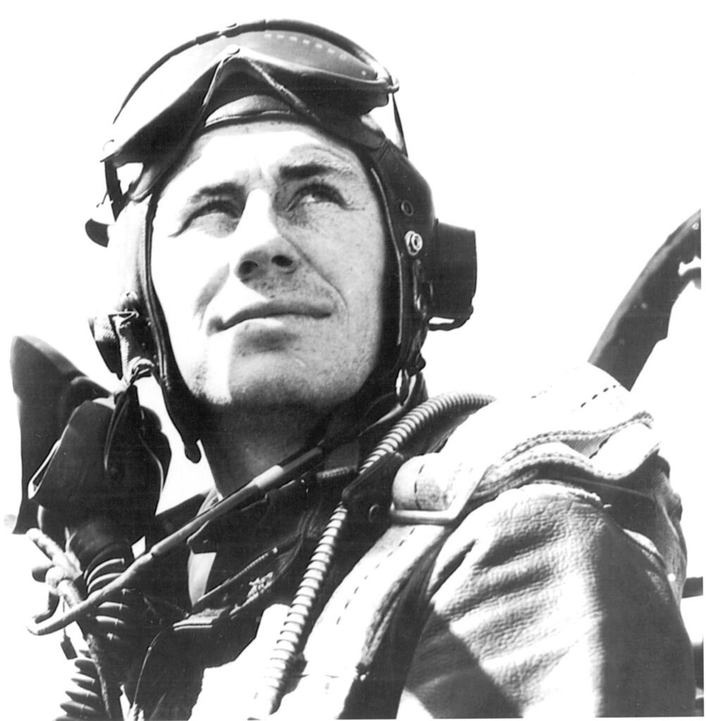 A young Chuck Yeager wears a vintage aviator hat and goggles.