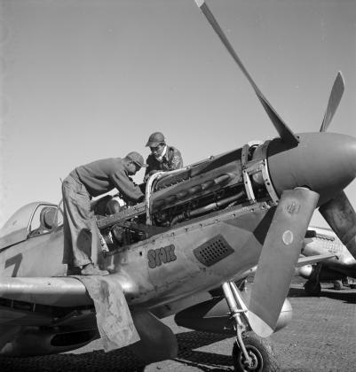 Two Airmen working on a plane.