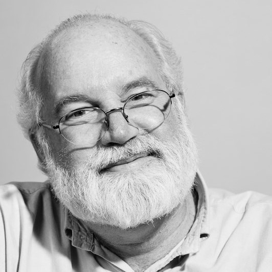 Headshot of Father Gregory Boyle with a soft expression and glasses.