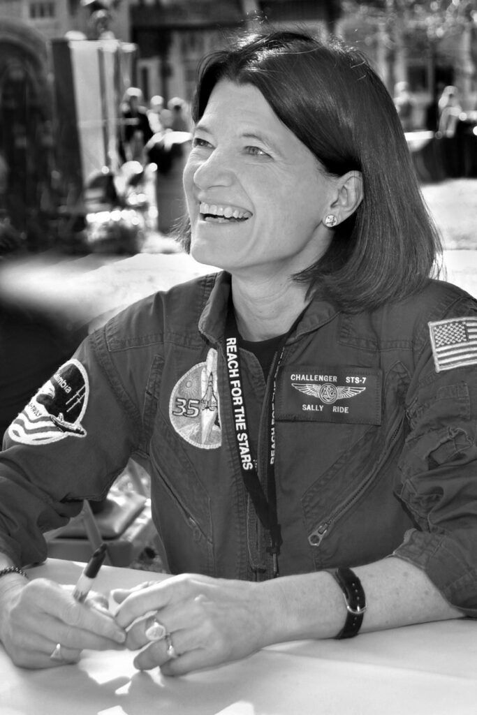 Sally Ride wears a NASA jacket with a bright smile.