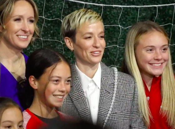Megan Rapinoe poses with young soccer players.
