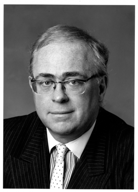 Headshot of Kevin Starr in a suit with a subtle smile.