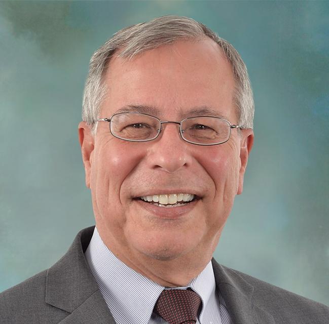 Headshot of a joyfully smiling Mike Ueltzen.