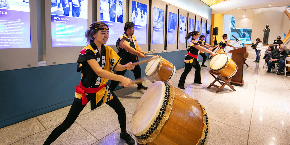 Taiko drummers perform for visitors in the museum lobby.